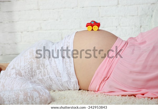Pregnant woman with a toy\
car