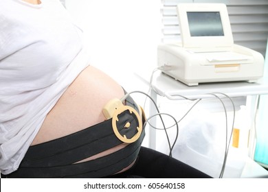 Pregnant woman undergoing cardiotocography. Antenatal care.