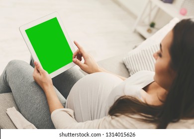 Pregnant woman using digital tablet with green screen for chroma key, shopping online on baby store, empty space - Powered by Shutterstock