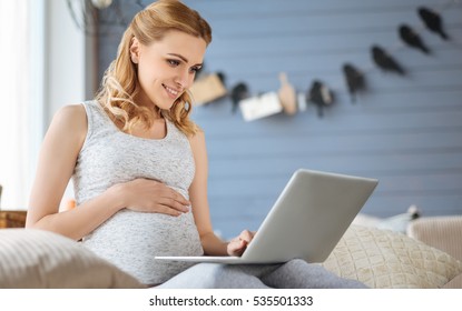 Pregnant Woman Using Laptop In Bed