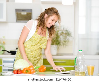 pregnant woman using a tablet computer to cook in her kitchen - Powered by Shutterstock