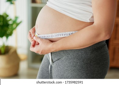 Pregnant Woman Using Tape Measure To Control The Abdomen