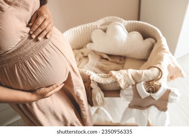 Pregnant woman waiting for a baby in the nursery near the cradle. - Powered by Shutterstock