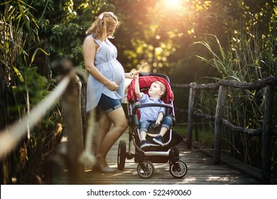 Pregnant woman walking with child in park