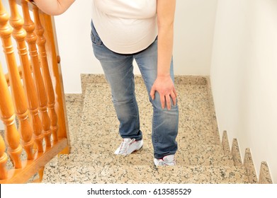 Pregnant Woman Walking Up The Stairs At Home And Touching His Knee By The Pain