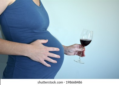 Pregnant woman want to drink alcohol craving red wine drink during pregnancy. Concept photo of Alcoholic pregnant woman lifestyle and medical health care. Real people. Copy Space