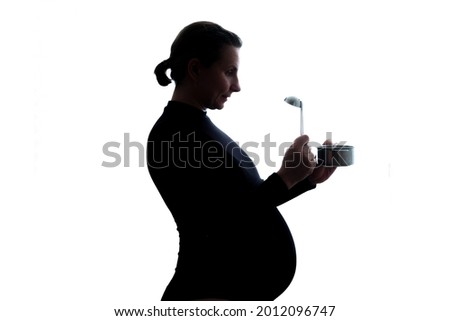 Pregnant woman wanting to eat something from snnall pan
