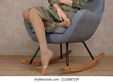Pregnant woman wearing compression stockings . Varicose veins prevention, Compression tights, relief for tired legs.