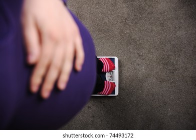 Pregnant Woman Weighing On Scale