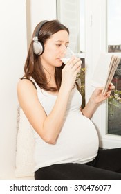 Pregnant Women Drink A Glass Of Milk And Listening To Music