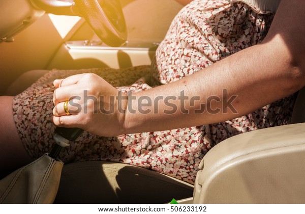Pregnant women are driving car,with sun light effect.   \
                                                                   \
                