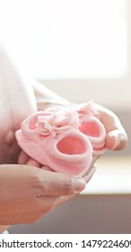 Pregnant women. Pink baby shoes - Shutterstock ID 1479224609