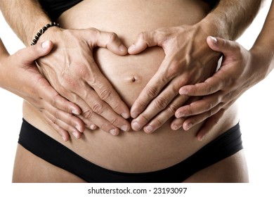 Pregnant Women Wrap Her Arms Around The Belly In The Form Of The Heart. Isolated On White.