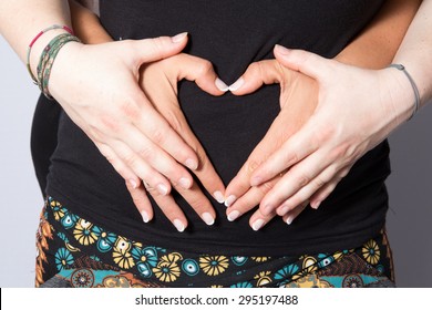 Pregnant Women Wrap Her Arms Around The Belly In The Form Of The Heart