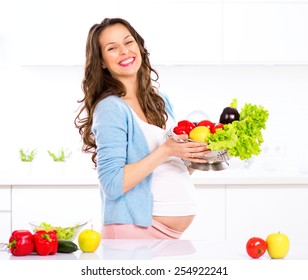 Pregnant Young Woman Cooking vegetables. Healthy Food - Vegetable Salad. Diet. Dieting Concept. Healthy Lifestyle. Cooking At Home. Prepare Food - Powered by Shutterstock