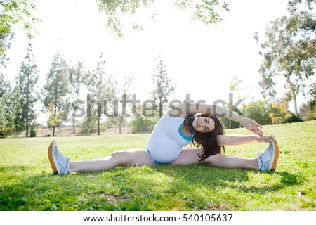 Pregnant young woman stretching to touch toes
