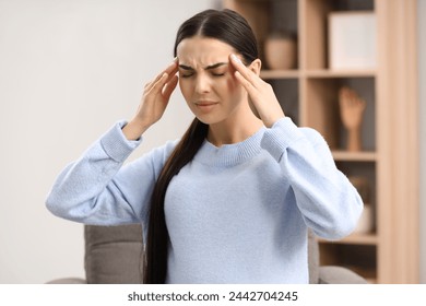 Pregnant young woman suffering from headache indoors - Powered by Shutterstock