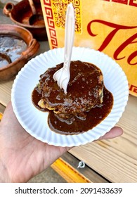 Pre-Hispanic Food. Amaranth Mole. Mexican Street Food. Hand Holding Food On A Disposable Plate And With Disposable Cutlery