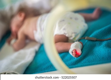 Premature baby in an incubator chamber