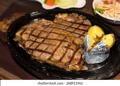 Premium American Prime Rib Steak On A Metal Plate Ready To Serve. The Focus Is Shallow Depth Of Field.