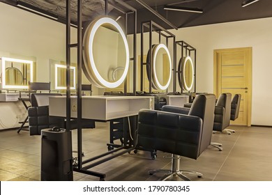 Premium coworking center for hair masters: workplace of the hairdresser with illuminated mirrors and comfortable chairs. Concept of contemporary interior design for hairdresser. Horizontal orientation