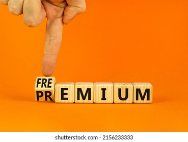 Premium or freemium symbol. Businessman turns wooden cubes and changes the concept word Premium to Freemium. Beautiful orange table orange background. Business premium or freemium concept. Copy space.