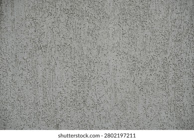 Premium full-frame texture shot showcasing a textured stucco wall facade in a clean, balanced horizontal composition. The image highlights a modern architectural exterior coated with mineral plaster, featuring a distinctive grooved, scratched, or bark-beetle (Koroed) pattern. The decorative surface displays a neutral monochromatic light grey or off-white color palette, with subtle shadows emphasizing the vertical and irregular micro-grooves. The even, sharp focus across the entire frame beautifully captures the gritty, coarse tactile details of the building material. An exceptional graphic background asset engineered for high-end digital texturing, website wallpapers, 3D architectural rendering overlays, and minimalistic design backdrops.
