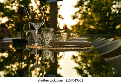 Premium Luxury Dining Setup At A Fancy Restaurant With Crystal Water And Wine Glasses Photographed On A Glass Table In Sunset Light. Restaurants Food And Drinks Industry.