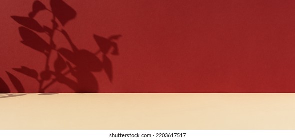 Premium podium with a shadow of plant leaves on a red wall and a beige table. Minimal abstract background for the presentation of a cosmetic product. Showcase, display case. - Shutterstock ID 2203617517