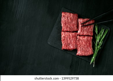 Premium raw Black Angus beef minute steak on Black wooden background. Slice wagyu for yakiniku