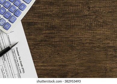 Premium Tax Credit Form With Calculator And Pen On The Wooden Table