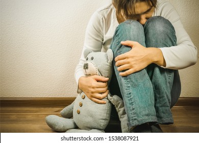 Prenatal loss concept - depressed woman holding teddy bear toy, copy space
