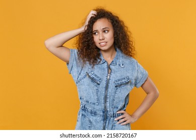 Preoccupied young african american woman girl in casual denim clothes isolated on yellow wall background studio portrait. People lifestyle concept. Mock up copy space. Put hand on head, looking aside - Shutterstock ID 2158720167