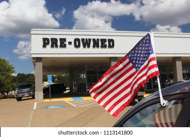 Pre-Owned Car Dealership with American Flag Shallow DOF, Focus on flagpole and stars 