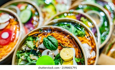 Pre-packaged vegetable salads displayed in a commercial refrigerator - Shutterstock ID 2198401791