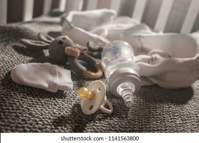 Preparation for the birth of a child.  Newborn baby clothe's and accessories in a cot. A toy, socks, blankets for a newborn in a baby bed. Waiting for a child. First day after birhday.