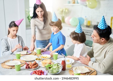 Preparation. Caring Latin Middle Aged Mother Serving Her Family While They Having Dinner, Celebrating Birthday Together At Home