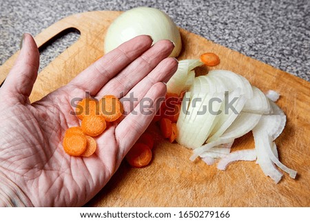 Preparation of carrots and onions for cooking. Slicing into pieces