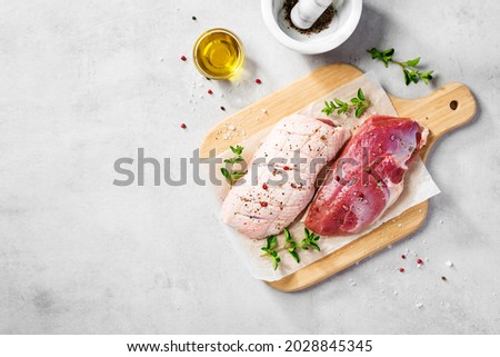 Preparation for cooking raw duck breast with ingredients. Light gray background, top view. Space for text