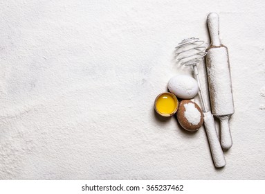 Preparation of the dough. Eggs with venicom and rolling pin in flour.  Free space for text . Top view - Shutterstock ID 365237462