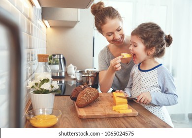 preparation of a family breakfast. mother and child daughter cut bread and cheese in morning
 - Powered by Shutterstock