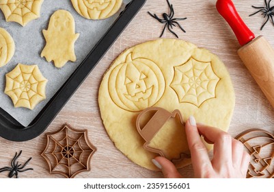 Preparation of festive cookies for baking in the oven. Ready-to-bake Halloween cookies shaped like pumpkins and ghosts - Powered by Shutterstock