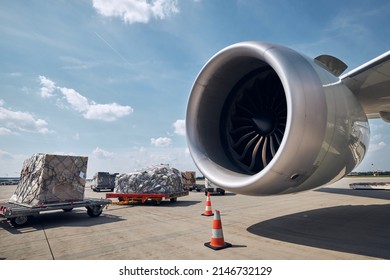Preparation freight airplane at airport. Loading of cargo containers against jet engine of plane. - Shutterstock ID 2146732129