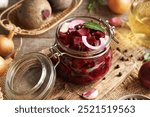 Preparation of homemade fermented beet kvass in a glass jar from fresh beetroot, onions, garlic and spices