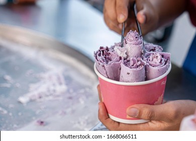 the preparation of ice-cream , Thai street food a Cup of delicious purple ice cream in the chef's hand. Close up
