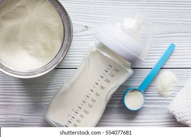 preparation of mixture baby feeding on wooden background top view