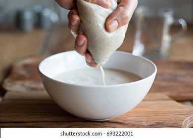 Preparation Of Nut Milk - Straining The Milk Through A Milk Bag