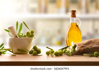 Zubereitung von Olivenölsaat in Keramik Glas für Körper und kulinarische Pflege auf Tisch mit Mörtel und Sack von Oliven. Vorderseite.