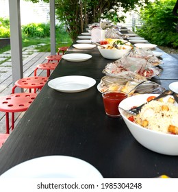Preparation Of An Outdoor Banquet Table By The Catering Service. Food Covered With Plastic
