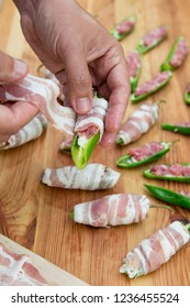 Preparation of peppers stuffed with cheese and minced meat and covered with bacon on cutting board - Shutterstock ID 1236455524